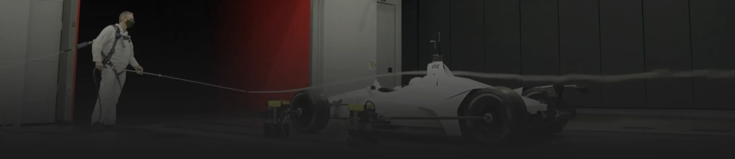 Man in wind tunnel with white car