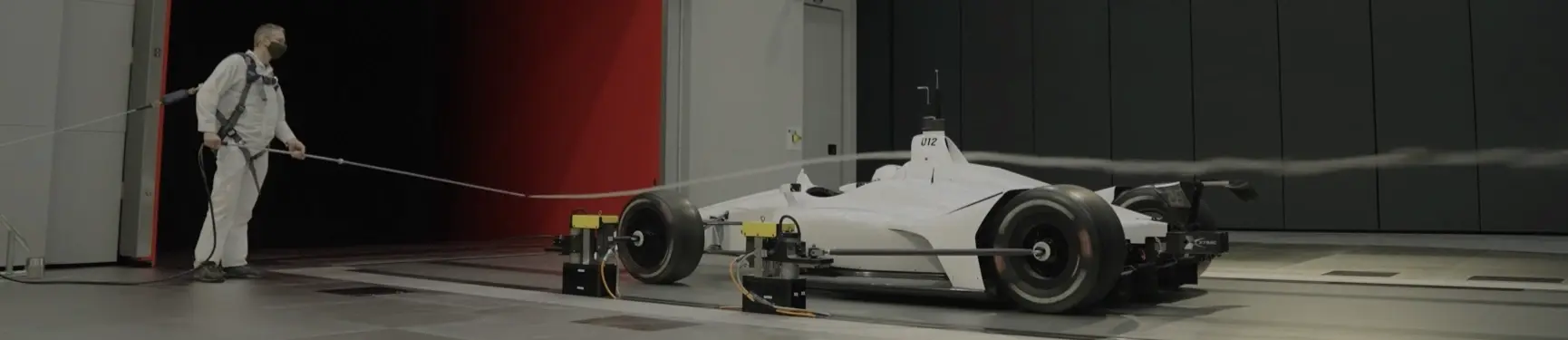 Man in wind tunnel with white car